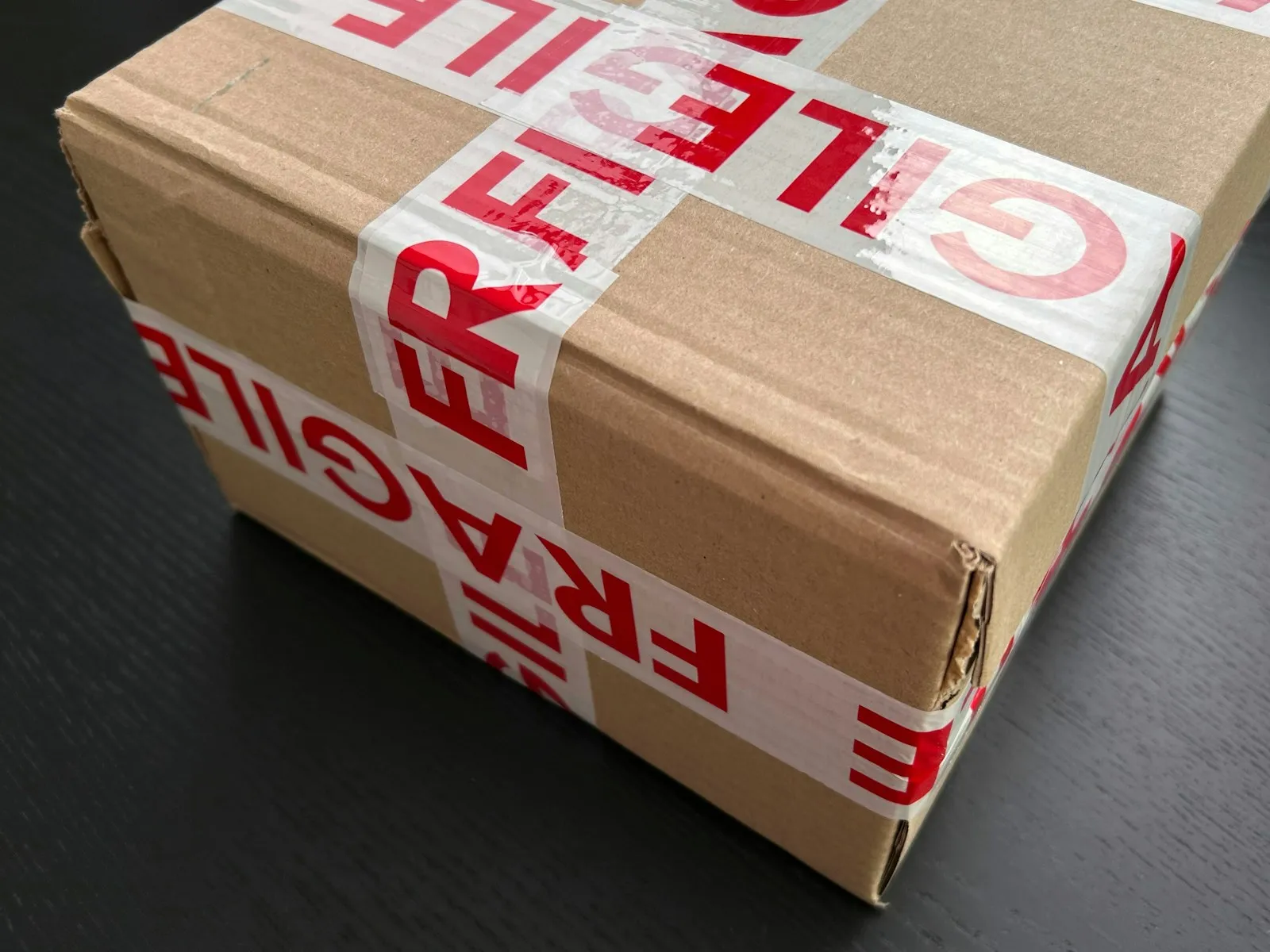 A sealed carton marked with fragile tape